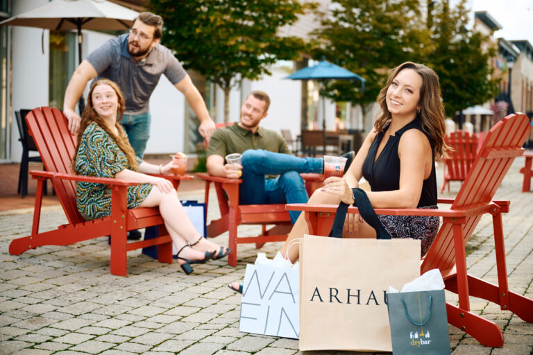 Two couples enjoying a break sitting in chairs while shopping at Legacy Village